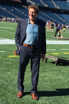 A man in suit and tie standing on the field.